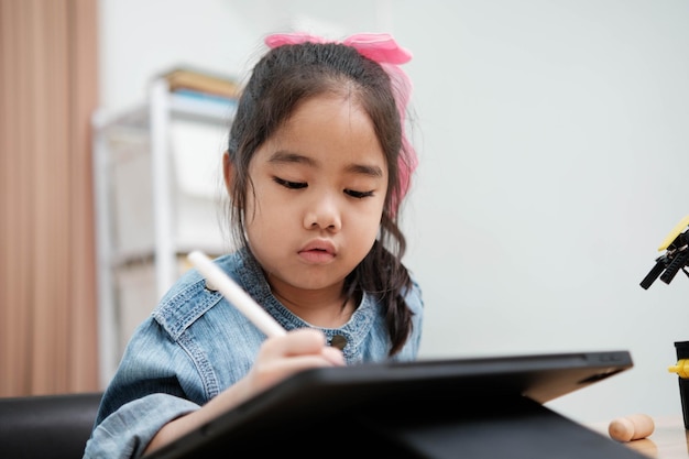 Une jeune fille joue avec une télécommande, un robot.