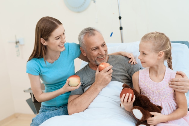 La jeune fille a un jouet dans ses mains avec un grand-père malade.