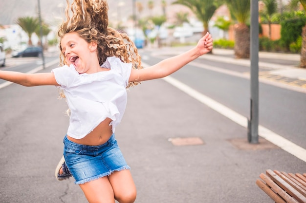 Une jeune fille joyeuse et heureuse de 8 ans sourit et profite de la journée des sourires et du bonheur pour l'âge de l'innocence et des vacances d'été avant la rentrée scolaire