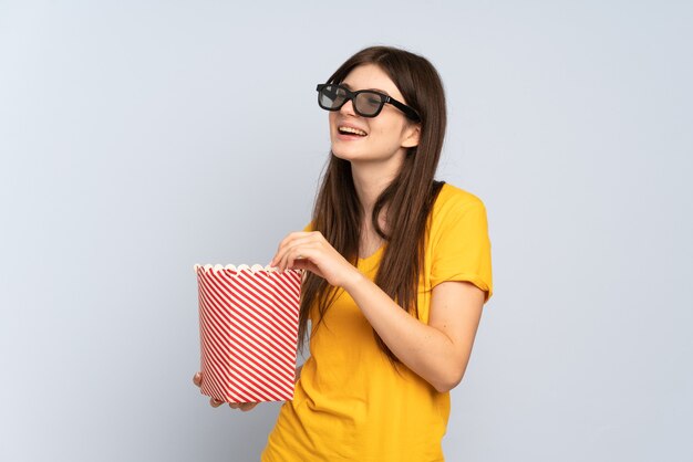 Jeune fille avec des lunettes 3d et tenant un grand seau de pop-corn