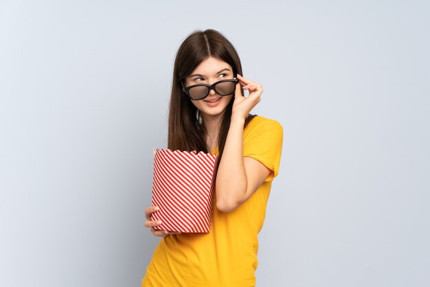 Jeune fille avec des lunettes 3d et tenant un grand seau de pop-corn