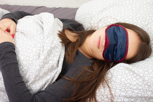 Photo jeune fille à la maison au lit, ment, dort