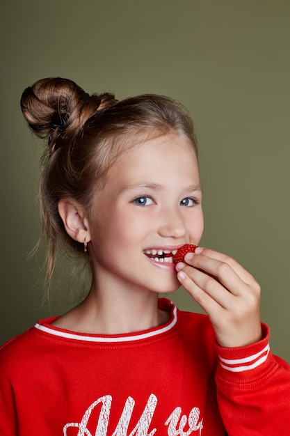 Photo jeune fille mange des fraises, des émotions gaies