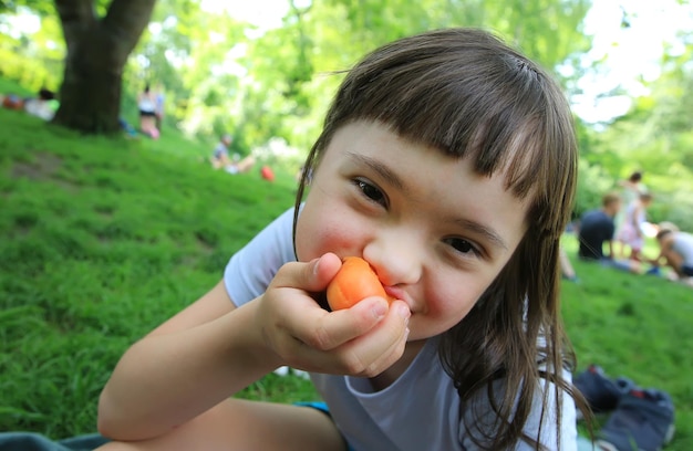 Jeune fille mangeant des abricots dans le parc