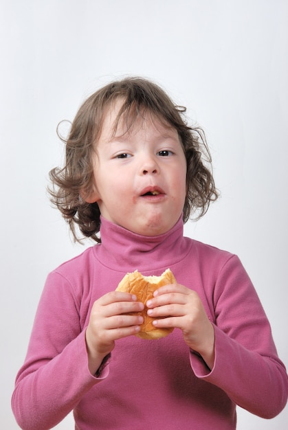 Une jeune fille mangeant un petit pain