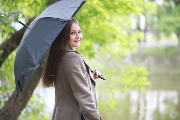 Jeune fille en manteau dans un parc de printemps