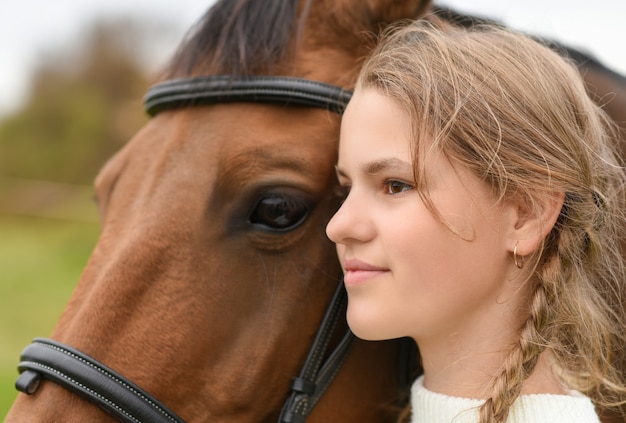 Jeune fille marchant avec un cheval dans la nature.