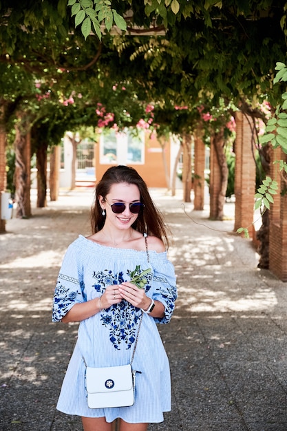 Une jeune fille marchant dans l'arrière-plan contre les arbres verts