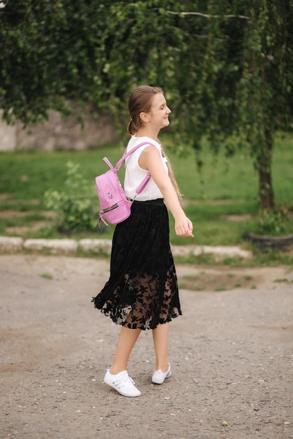 Jeune fille marchant dans le parc avec sac à dos