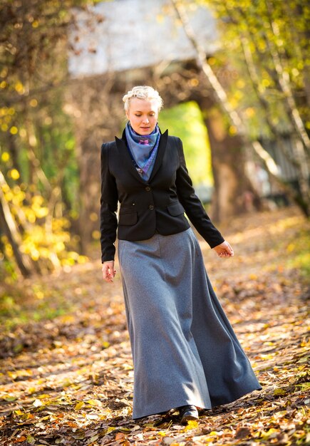 Jeune fille marchant dans le parc de la ville d'automne