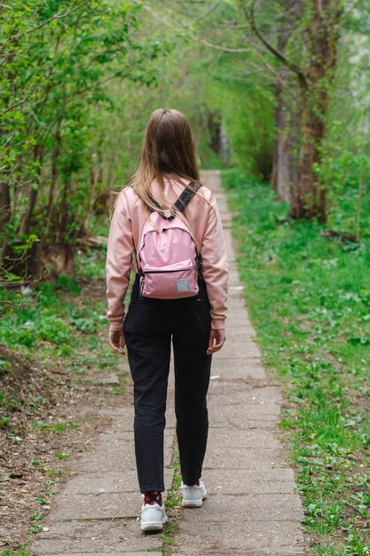 Jeune fille marchant le long d'un chemin dans la forêt