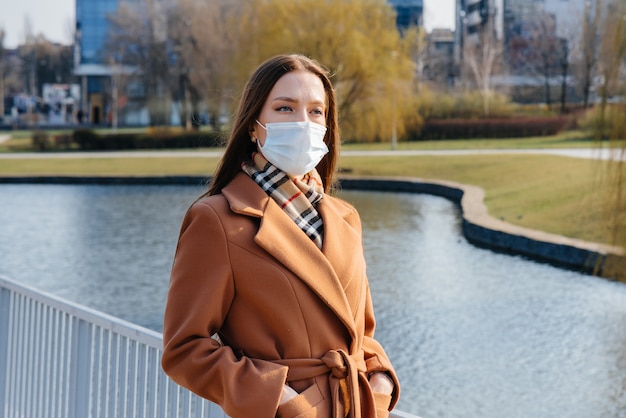 Une jeune fille marche dans un masque pendant la pandémie et le coronovirus. Quarantaine