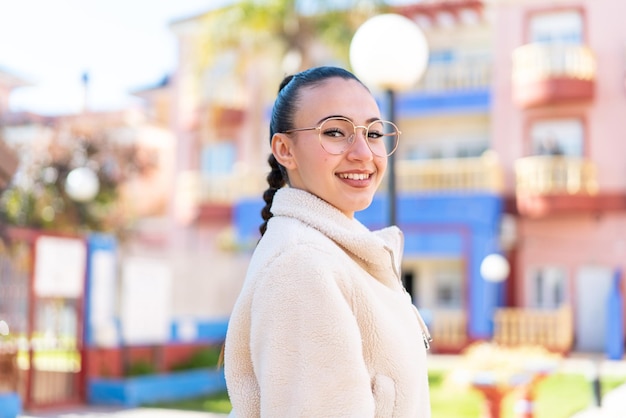 Jeune fille marocaine à l'extérieur avec une expression heureuse