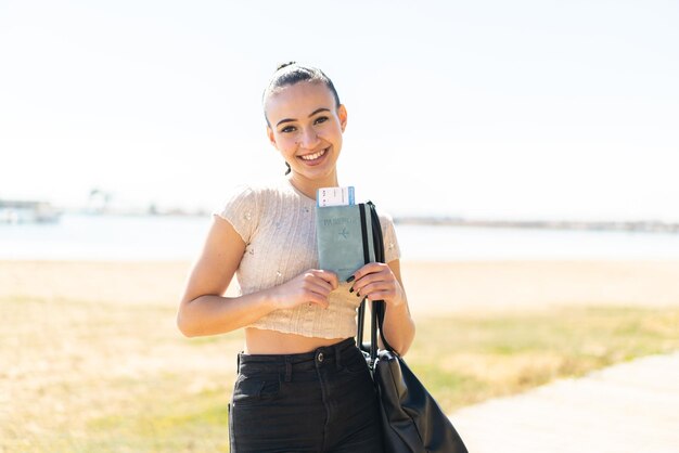 Jeune fille marocaine à l'extérieur tenant un passeport avec une expression heureuse