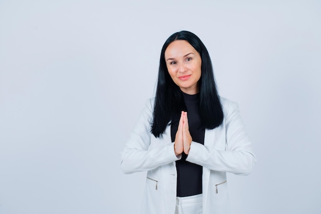 Jeune fille mendie en se tenant la main sur fond blanc