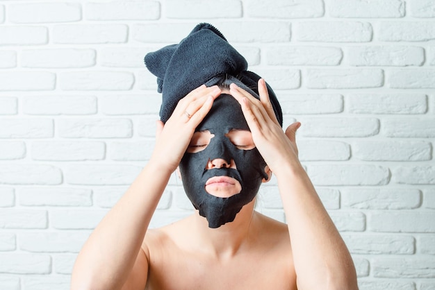 jeune fille met sur le visage un masque en tissu coréen pour la beauté de la peau