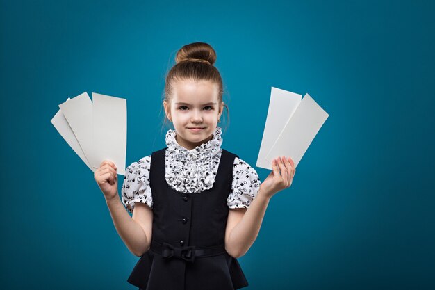 Jeune fille mignonne caucasienne montrant des billets et souriant