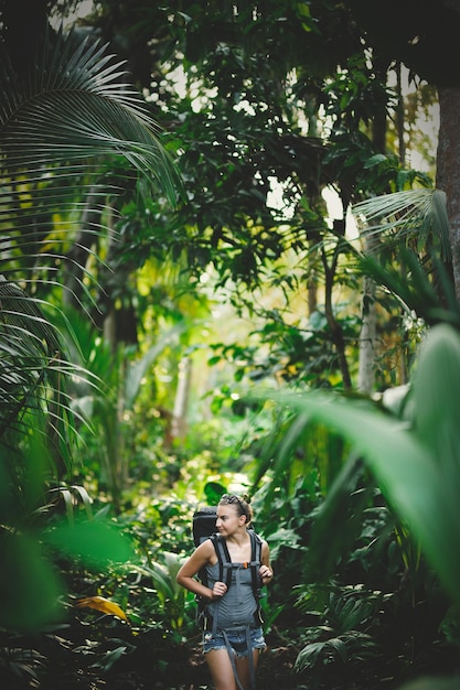 Jeune fille mince avec un sac à dos de randonnée dans la jungle. White Caucasian girl randonnées dans la jungle