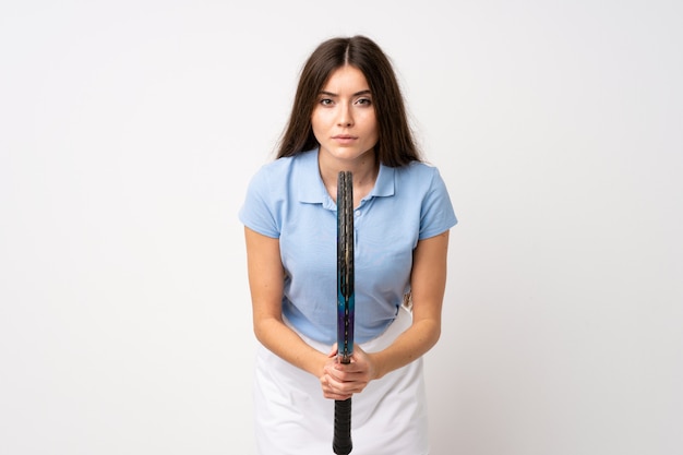 Jeune fille sur un mur blanc isolé, jouer au tennis