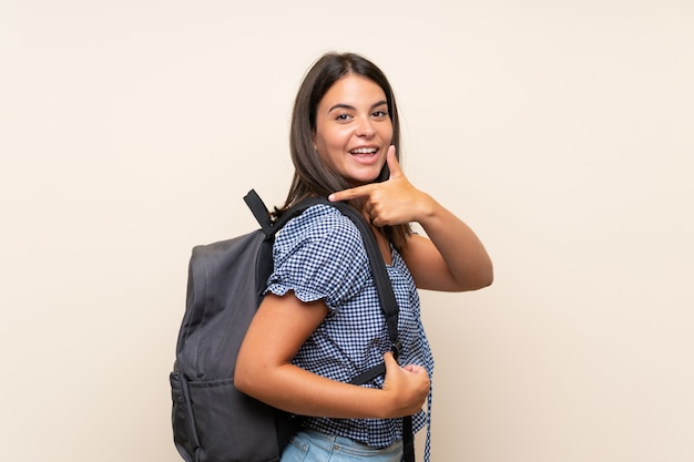 Jeune fille sur un mur isolé avec sac à dos