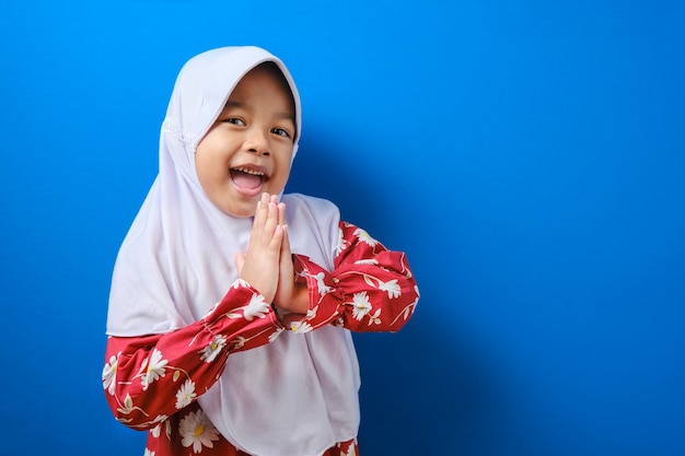 Jeune fille musulmane asiatique portant le geste du hijab en saluant et en accueillant l'invité pour l'Aïd Moubarak