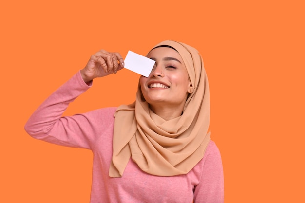 Jeune fille musulmane portant le hijab souriant et tenant une carte modèle pakistanais indien