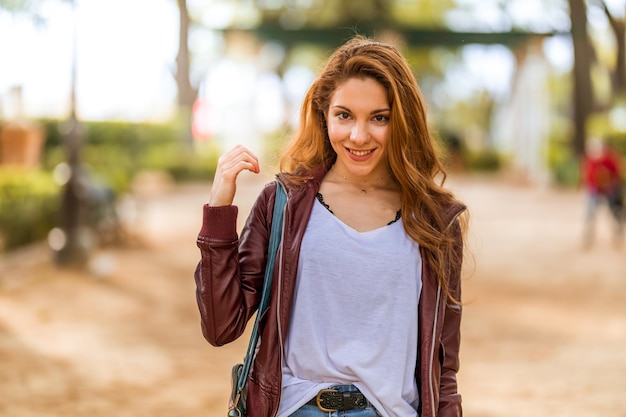 Jeune fille naturelle marchant et portant une tenue décontractée dans le parc