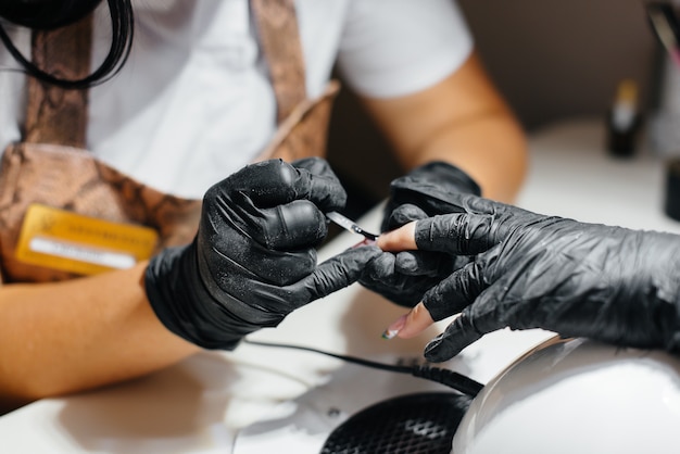 Une jeune fille obtient une manucure en gros plan sur ses mains dans un salon de beauté. Salon de beauté.