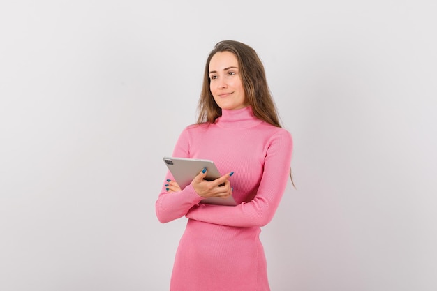 Jeune fille avec ordinateur planshet regarde à gauche sur fond blanc