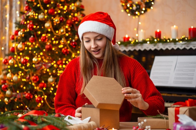 jeune fille ouvre le cadeau de Noël