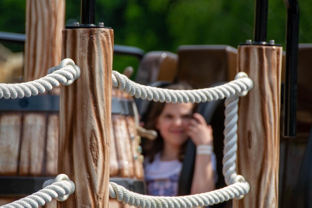 Une jeune fille parle sur un téléphone portable dans une cage en bois.