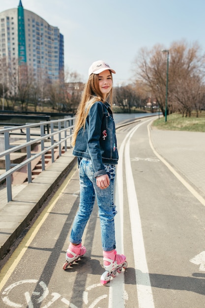 Jeune fille sur patins à roues alignées dans la ville