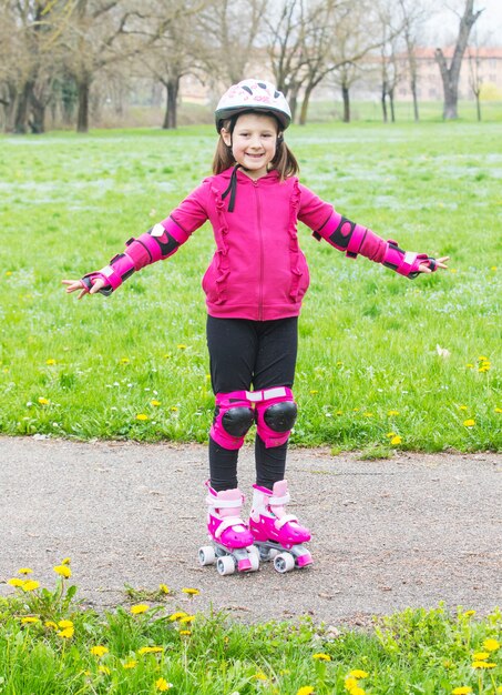 Jeune fille avec des patins à roulettes dans le parc