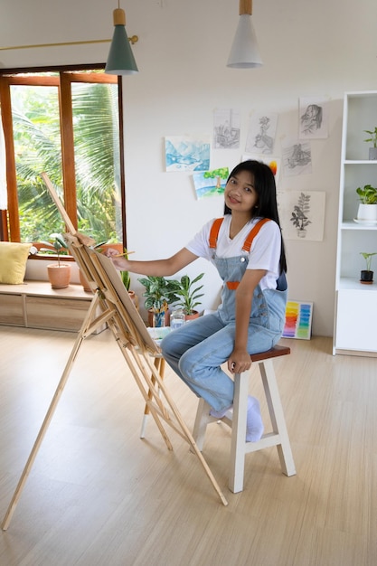 Jeune fille peignant sur papier à la maison cadre en boisLoisirs et études d'art à la maison