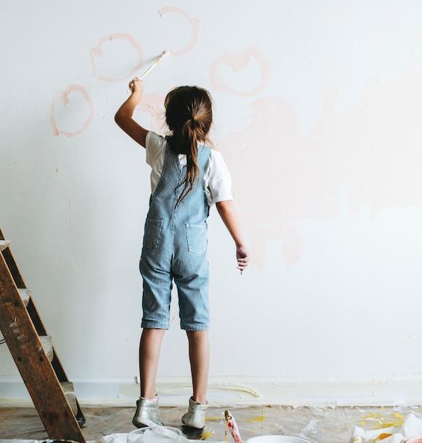 Jeune fille peindre les murs rose