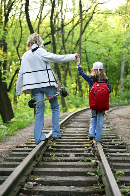 Jeune fille avec un petit enfant marchant sur les voies ferrées