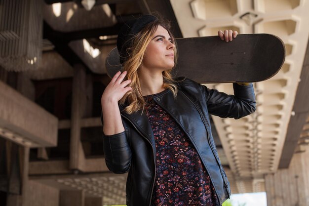 Jeune fille avec la planche à roulettes en levant