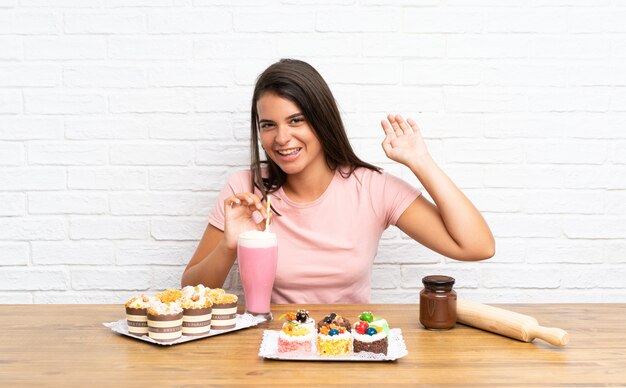 Jeune fille avec plein de gâteaux différents