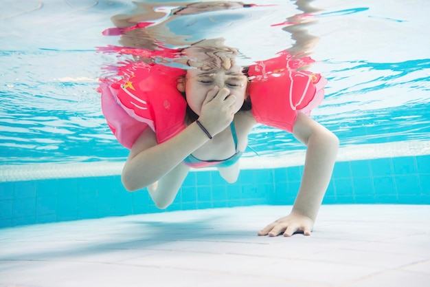 Jeune fille plongeant dans la piscine s'amusant dans le parc aquatique