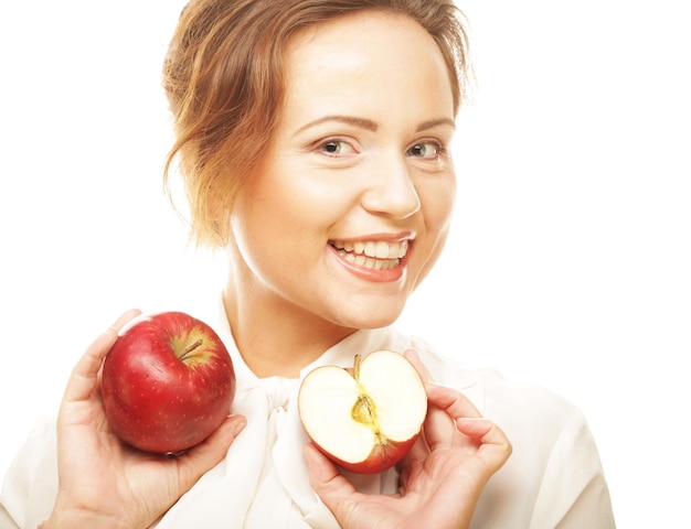 Jeune fille avec une pomme rouge à la main sur fond blanc