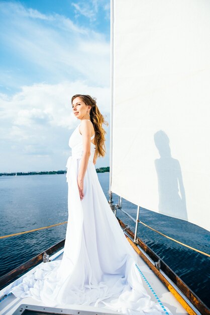 Jeune fille sur le pont du yacht blanc en bois à voile