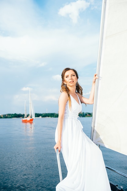 Jeune fille sur le pont du yacht blanc en bois à voile