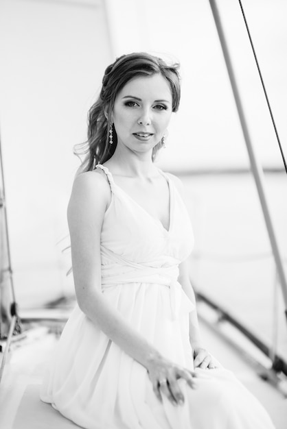 Jeune fille sur le pont du yacht blanc en bois à voile