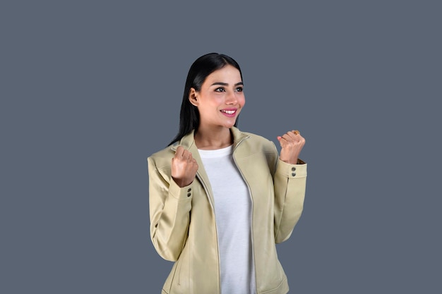 Jeune fille portant une veste avant pose avec les poings à côté de se sentir heureux modèle pakistanais indien