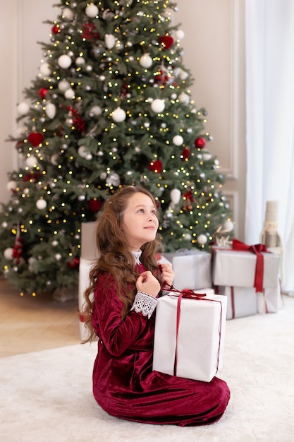 Jeune fille posant avec des cadeaux de Noël