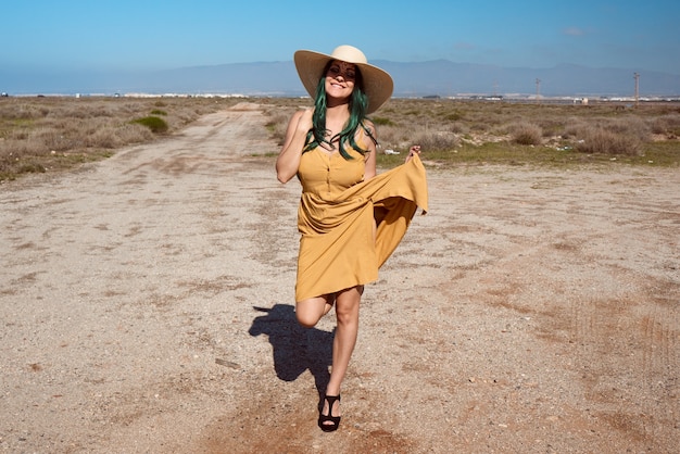 jeune fille posant dans un chapeau dans le désert. Concept de mode de vie