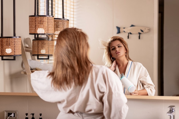 Une jeune fille pose en regardant dans le miroir