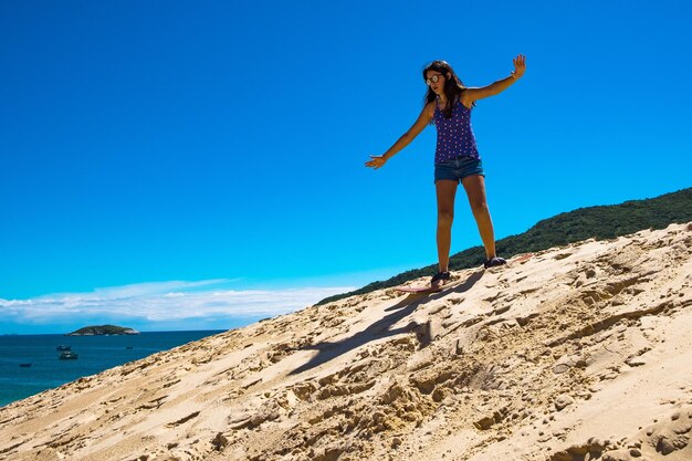 Jeune fille pratiquant le sandbord dans les dunes de Florianopolis, Brésil