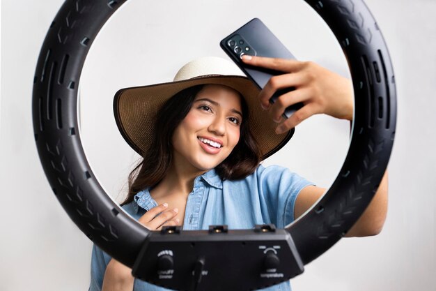 Jeune fille prenant un selfie avec un anneau lumineux