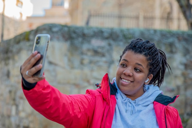 Jeune fille prenant un selfie en se tenant debout dans la ville